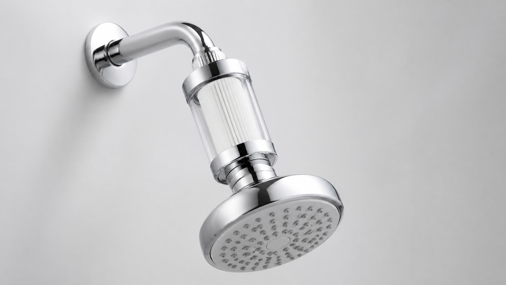 Chrome filtered shower head with a replaceable filter cartridge on a light background